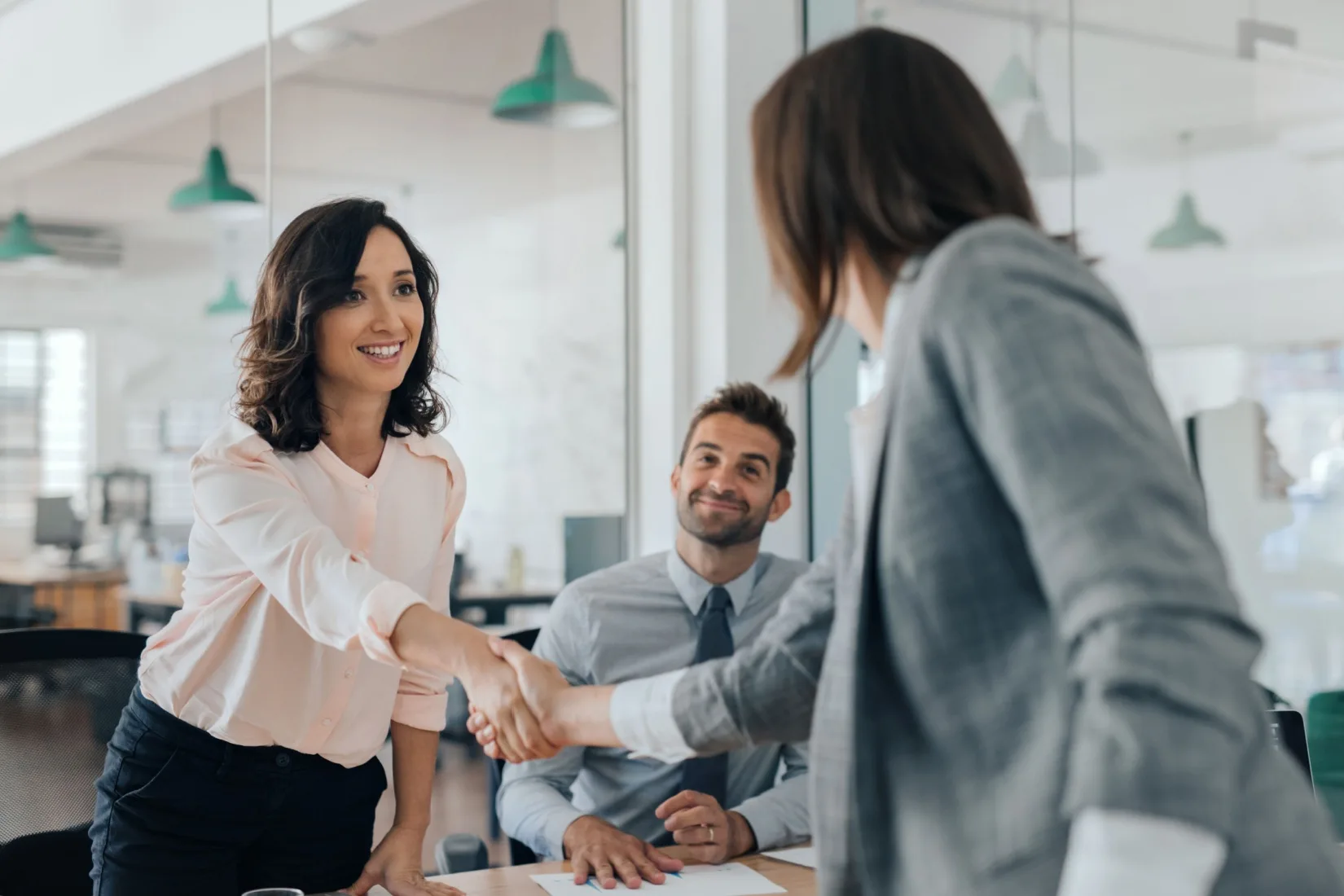 Two women shaking hands.