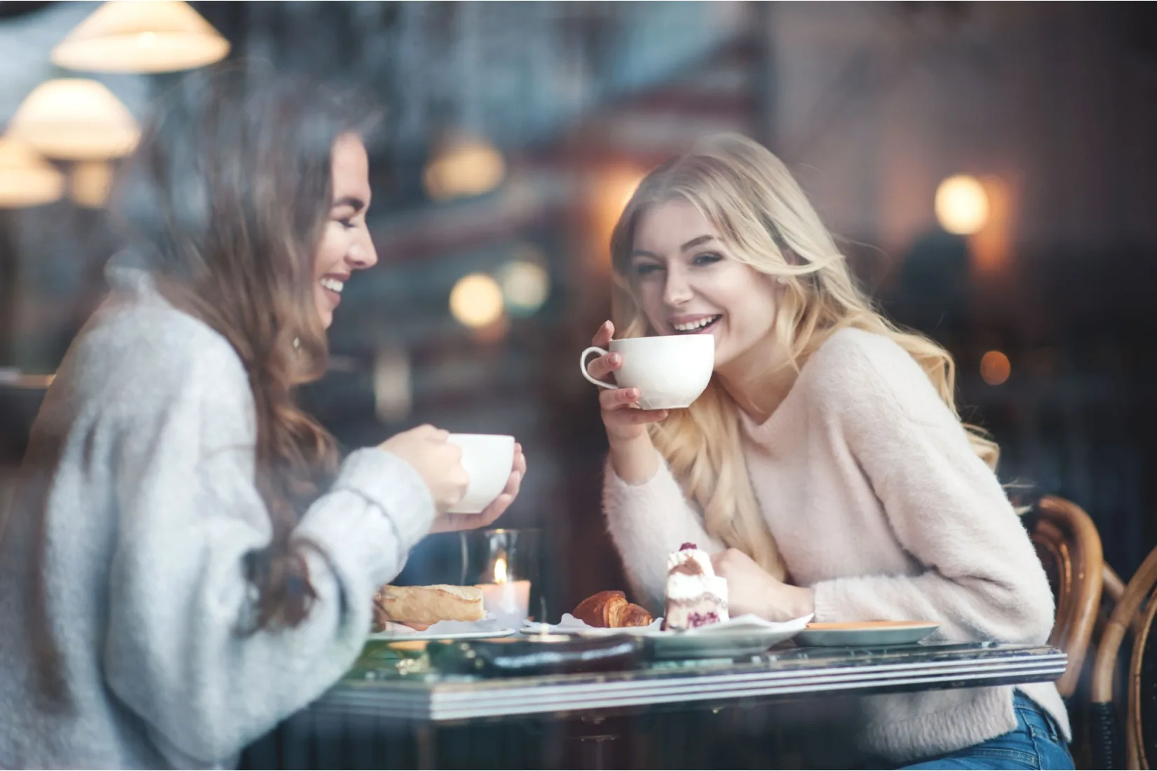 Two women talking and drinking coffee.