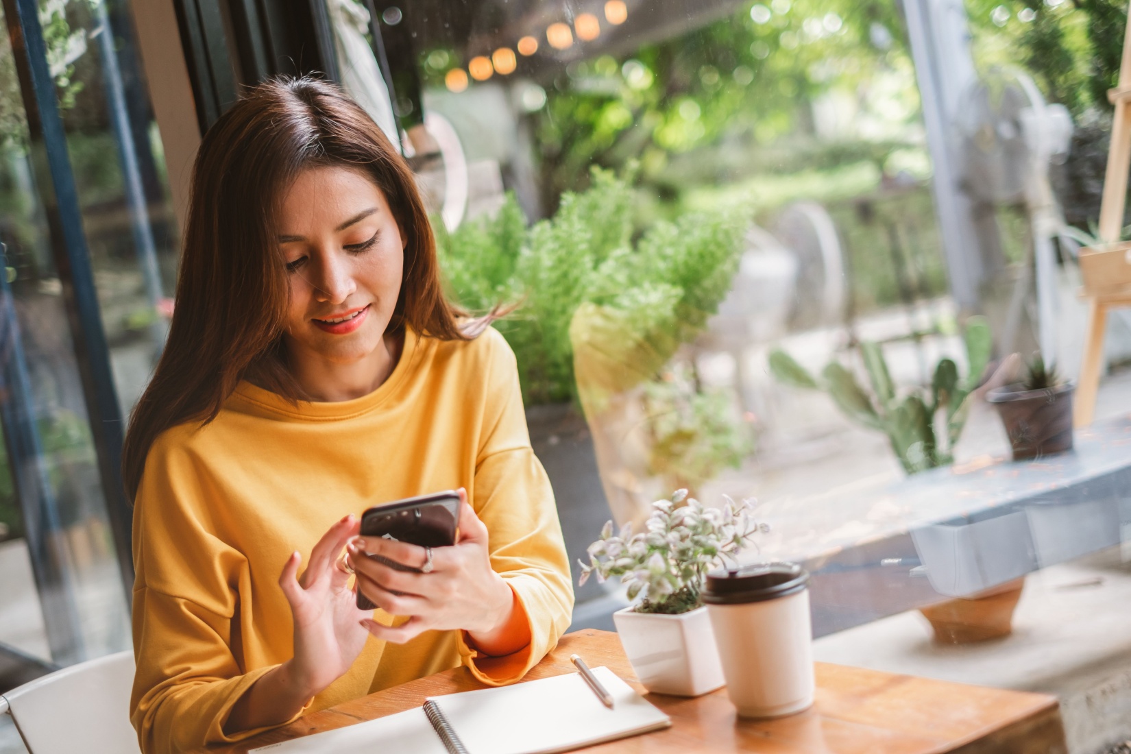 A woman using her phone in a café.