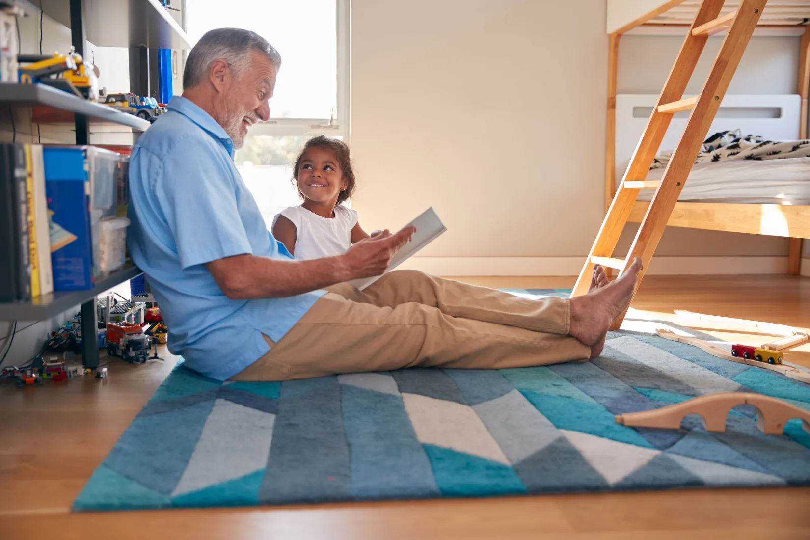 A grandfather reads to his granddaughter.