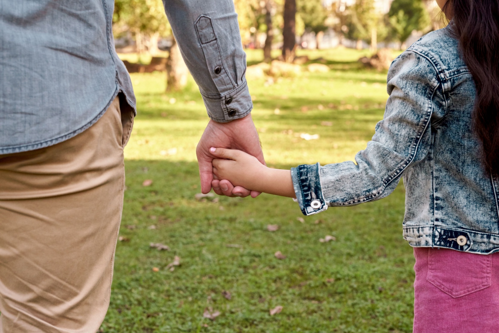 Parent and child holding hands.