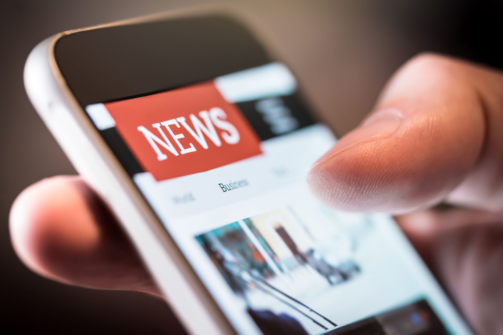 A person using a smartphone to read the news.