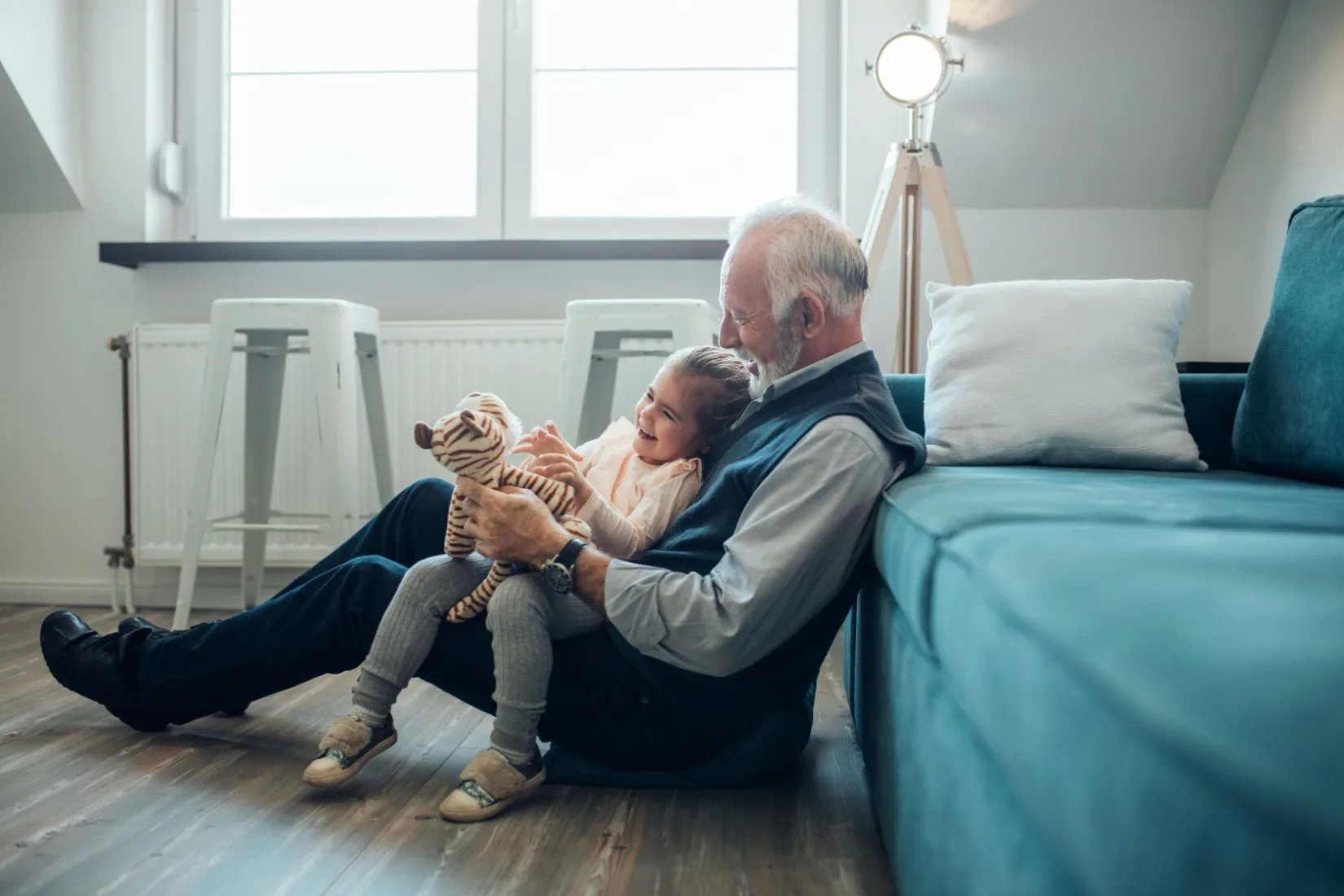 A grandfather playing with his granddaughter.