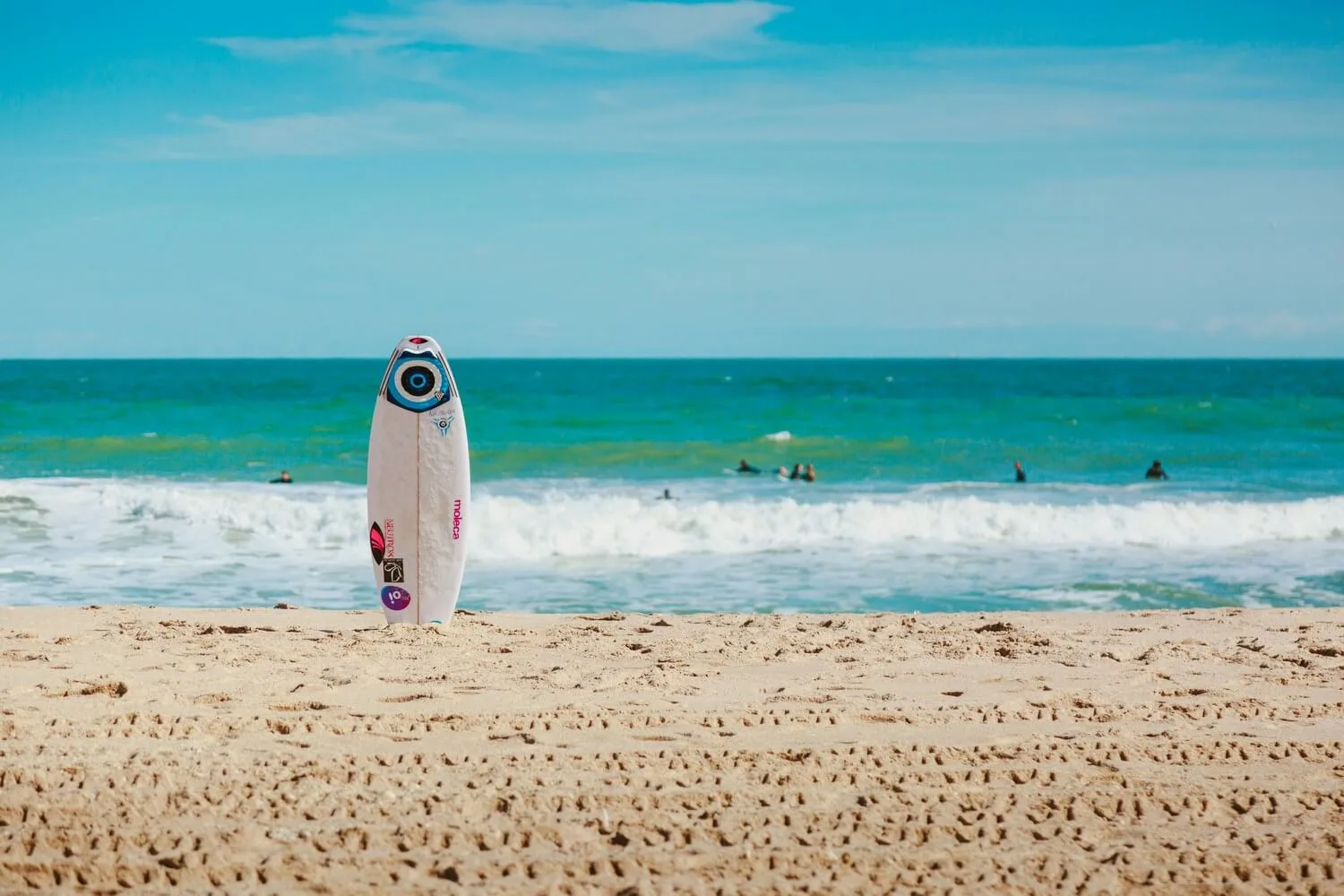 Surfboard standing up in the sand