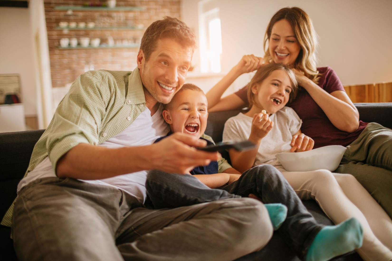 A young family watching TV together.