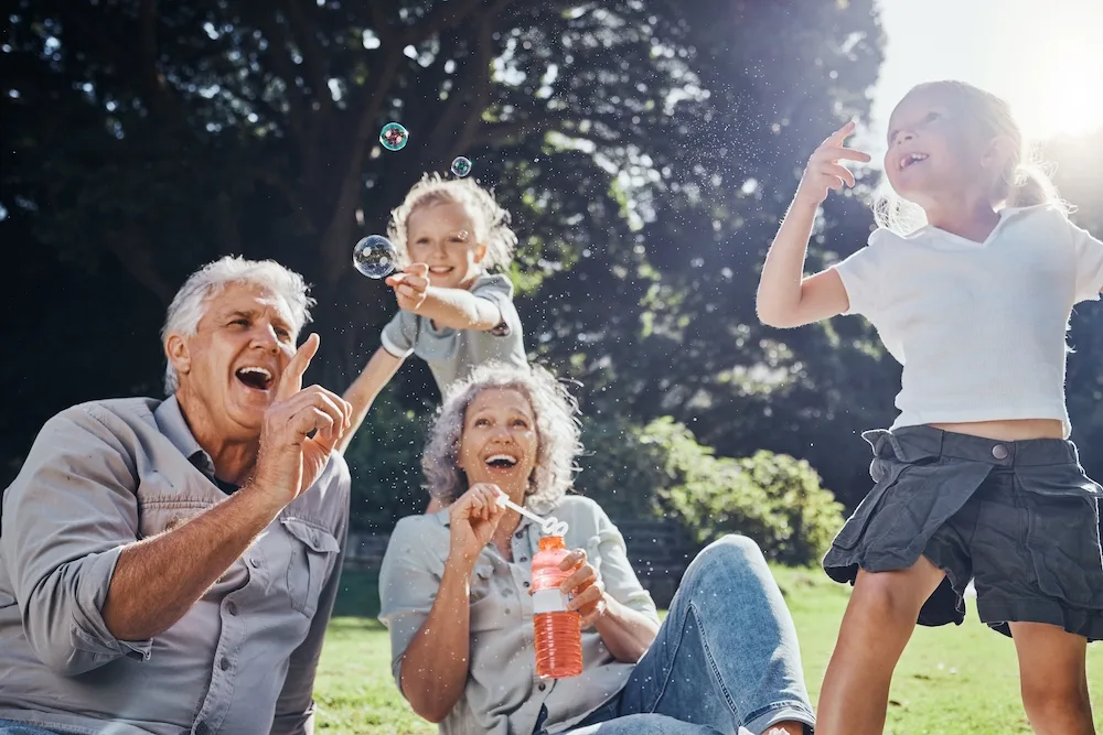 Grandparents blowing bubbles with their grandchildren.