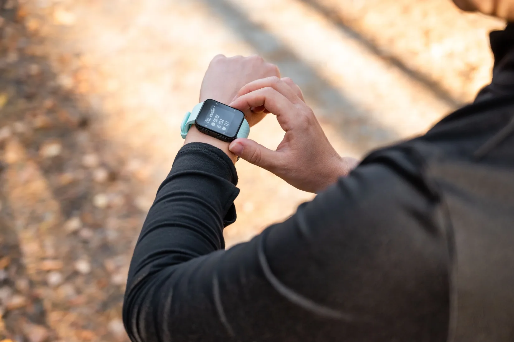 A runner looking at the time on their watch.