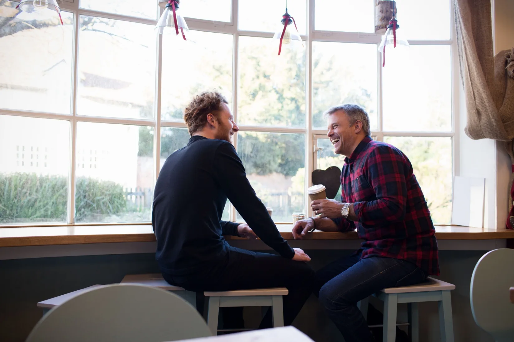Two men taking in a coffee shop.
