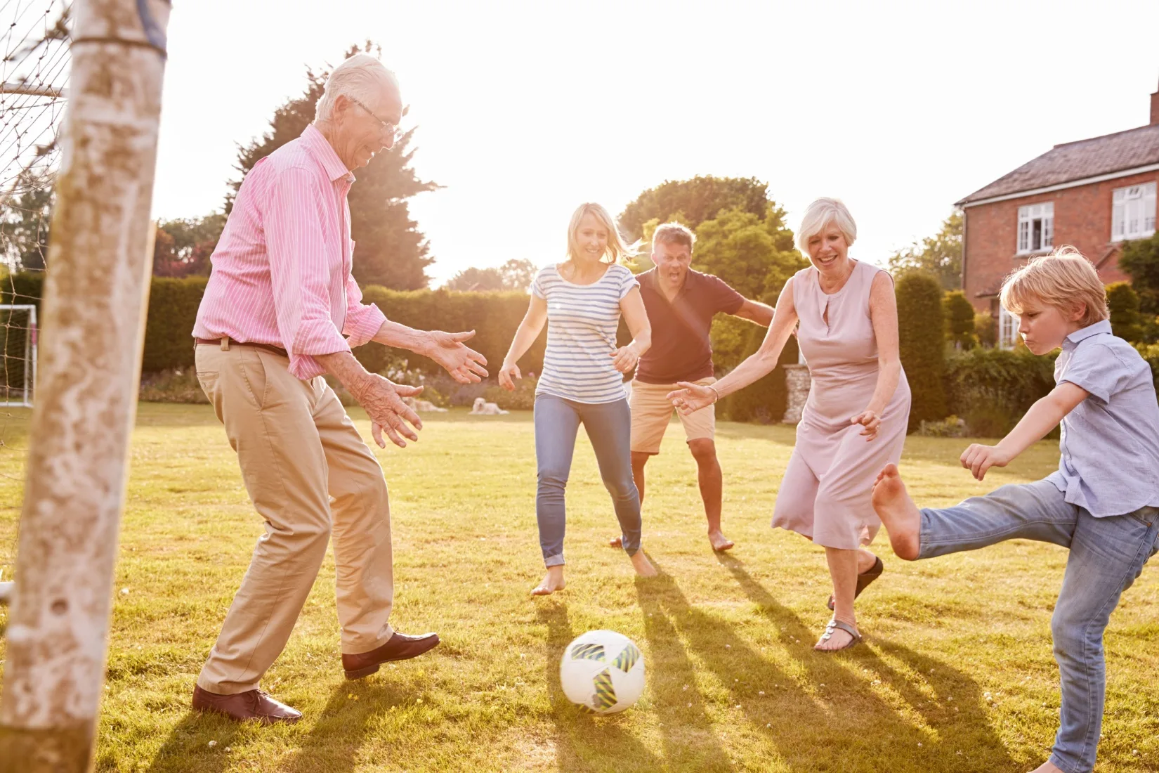 A family playing football in a garden.