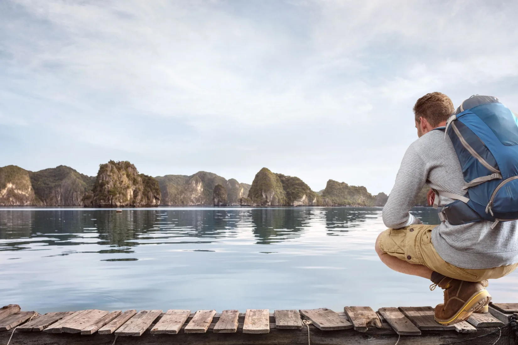 Traveller crouching on a jetty.