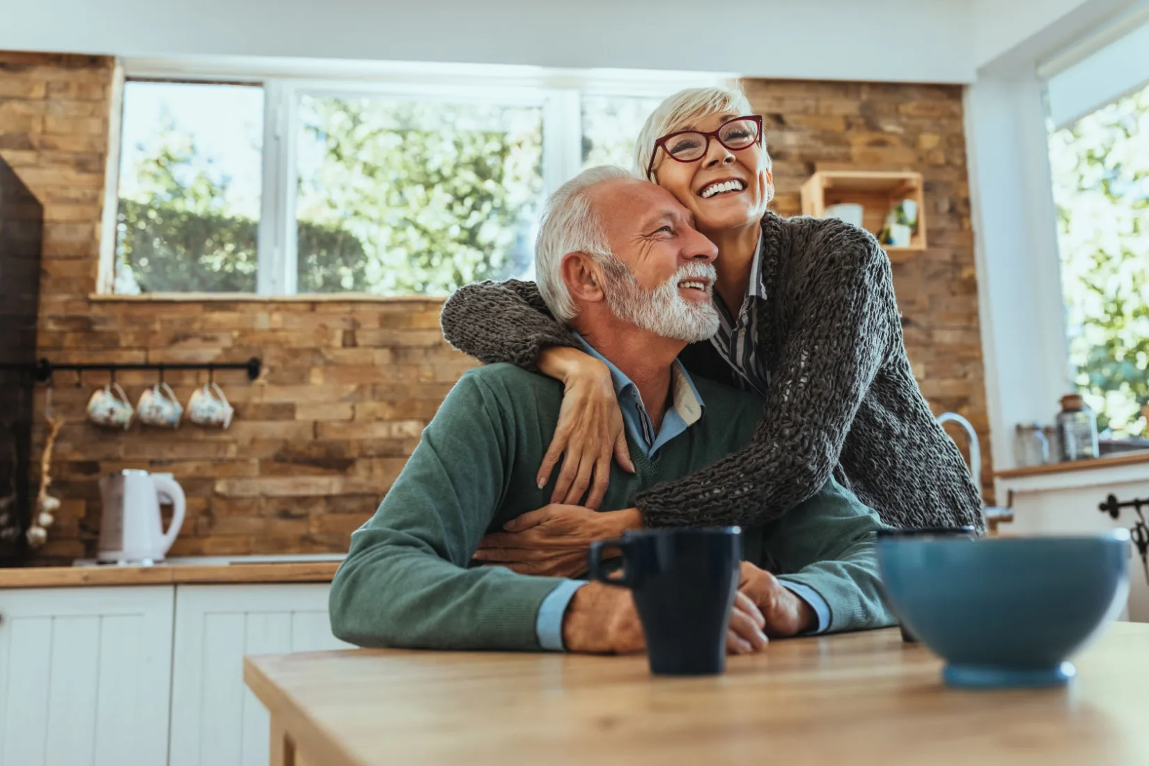 A couple hugging in their home.
