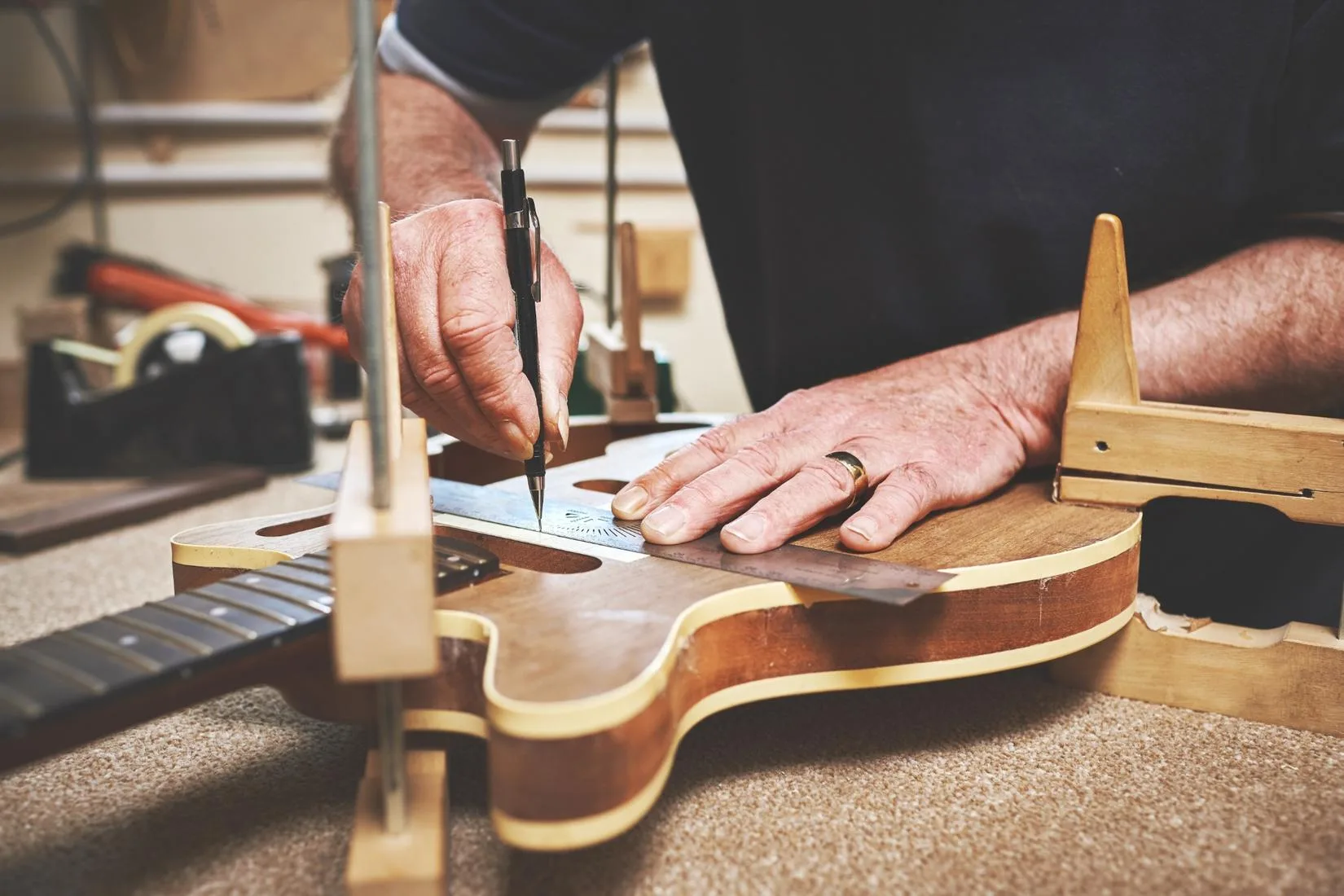 A man fixing a guitar in a workshop.