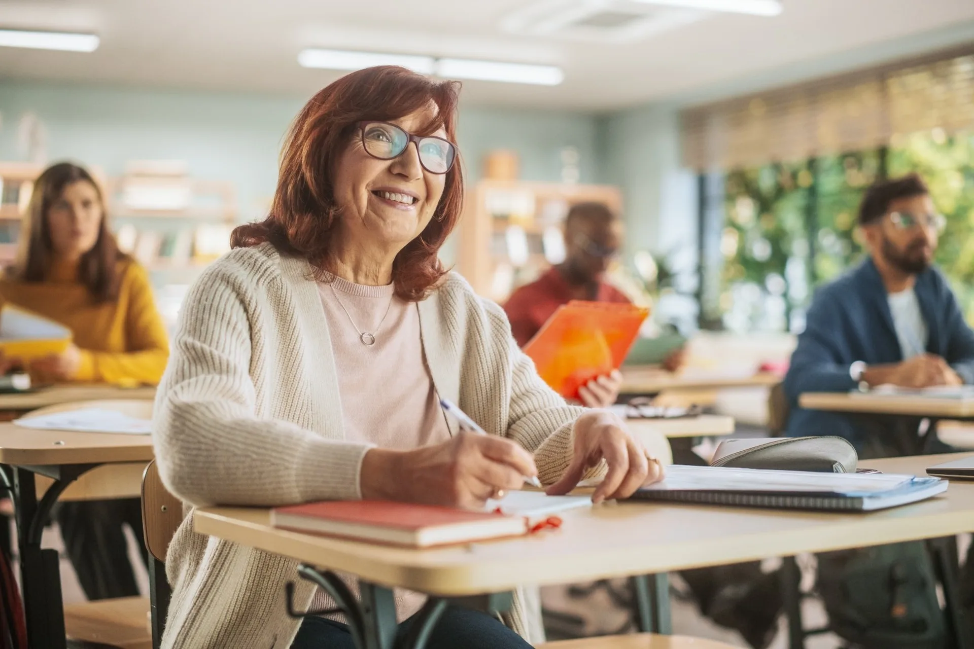 Happy senior woman taking notes in a classroom