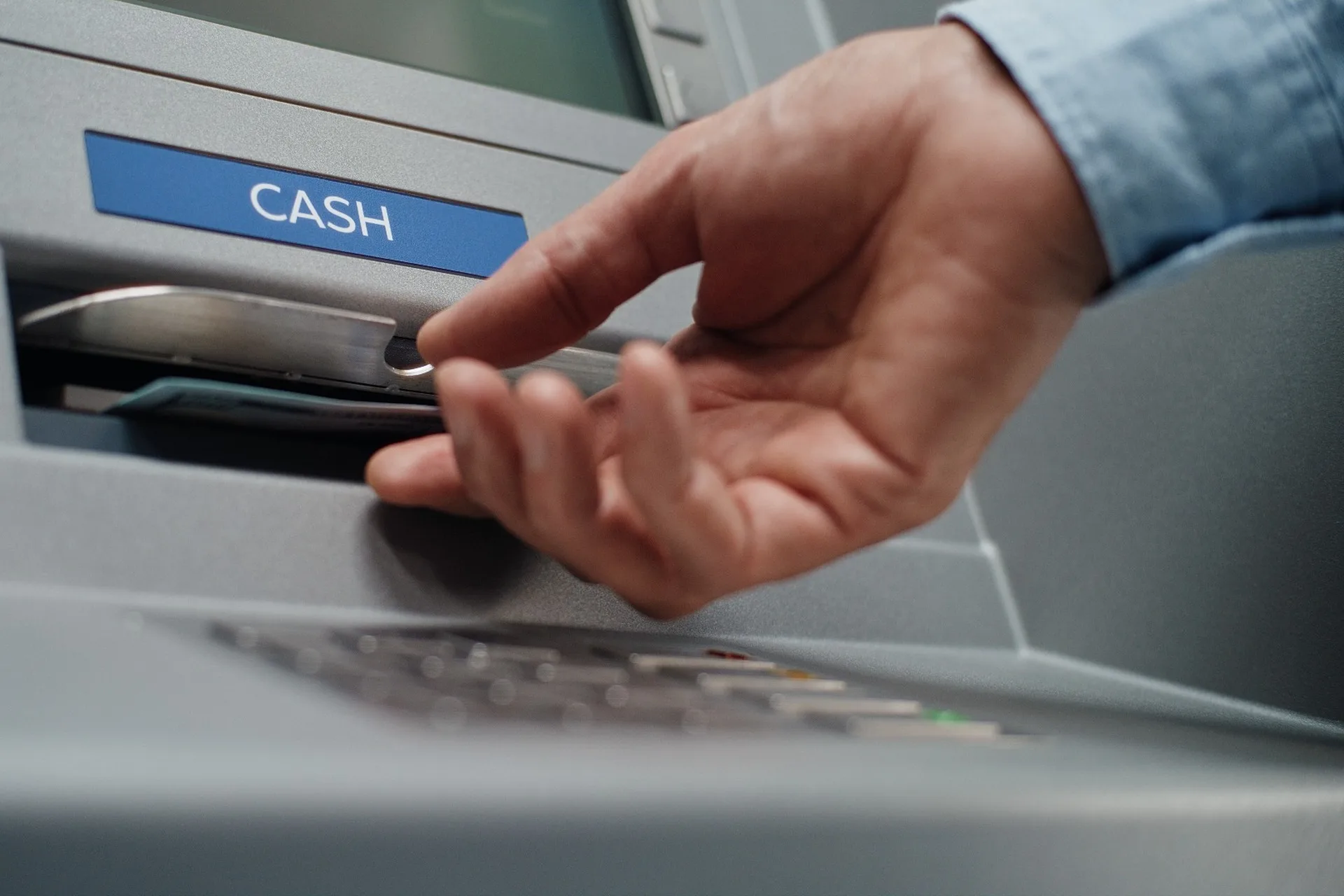 A person using an ATM to withdraw cash.