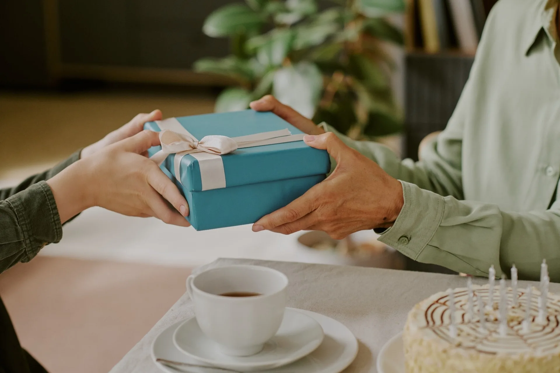 A person gifting a wrapped birthday present.
