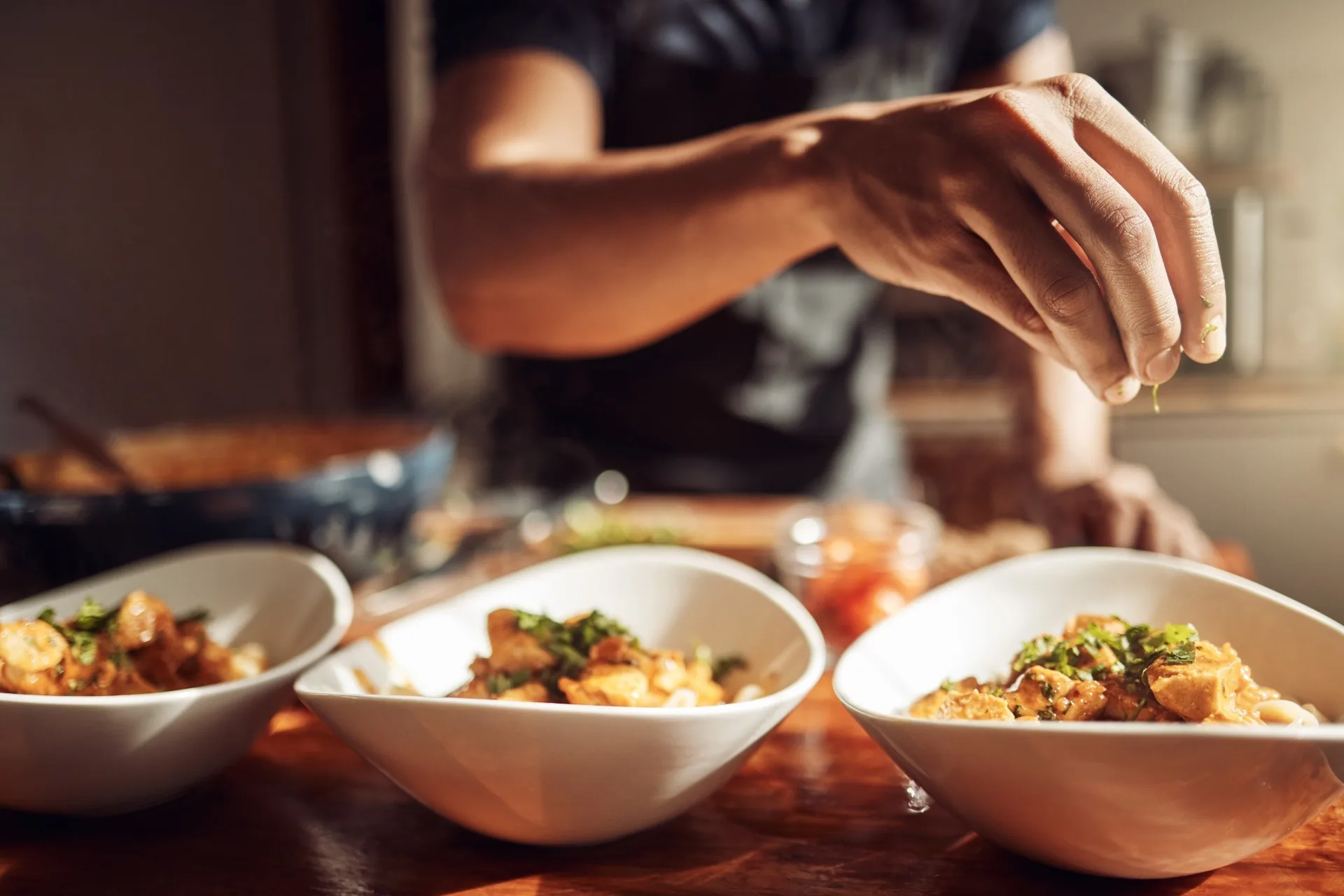 A man adding garnishes to a meal.